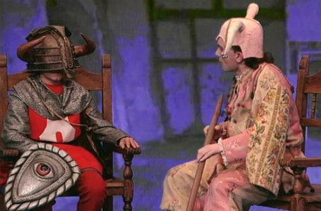 A jester sits with a knight in the second series of El Rescate del Talisman.